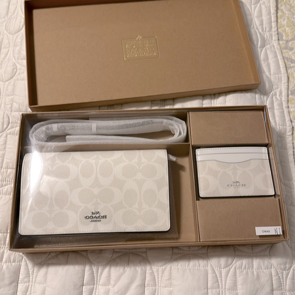 Coach clutch with crossbody strap and card holder.